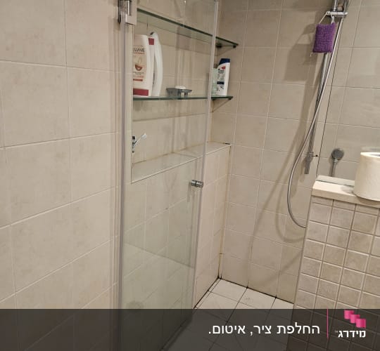 מקלחת עם דלת זכוכית, מדפים ומוצרים לטיפוח